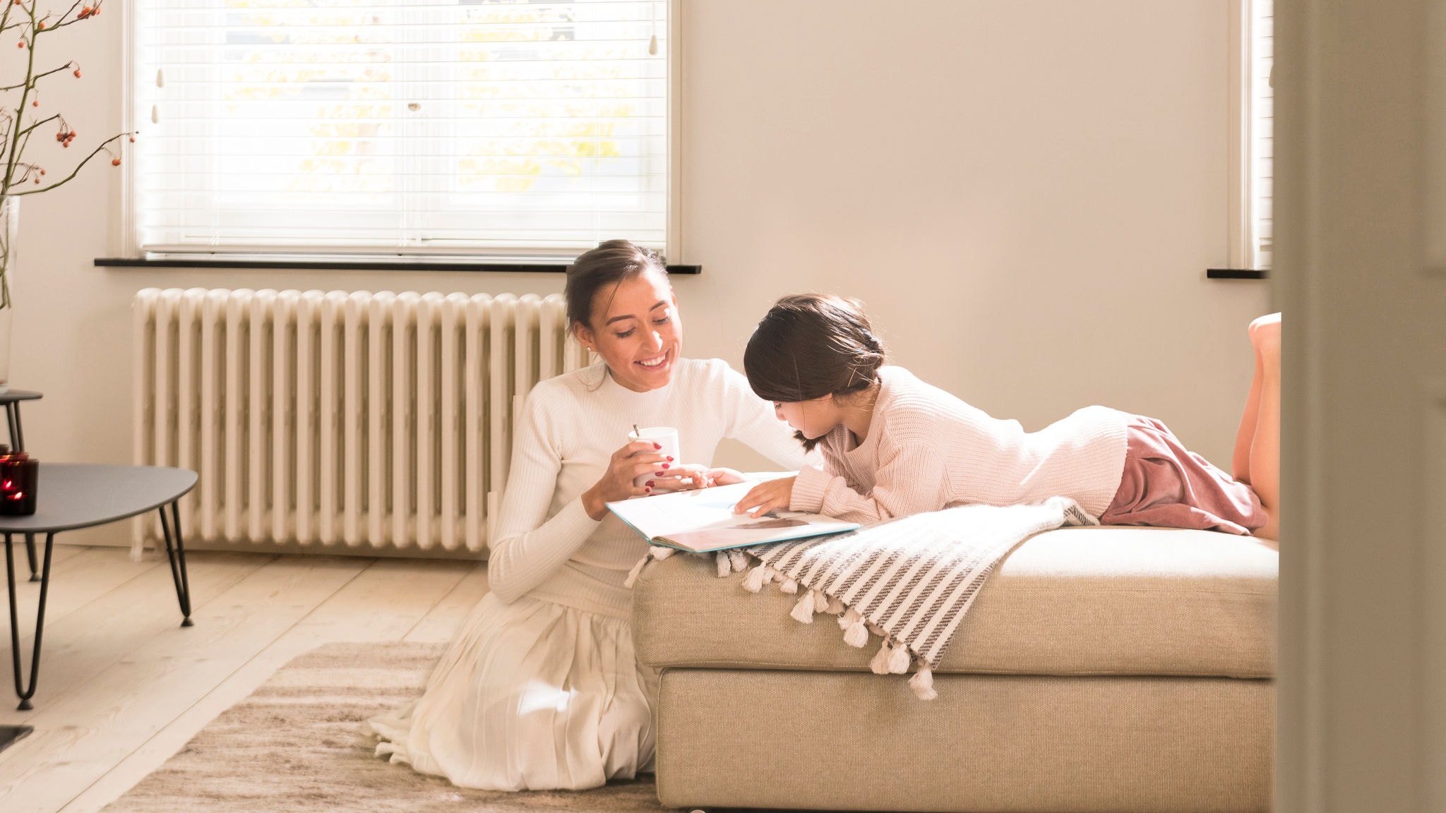 Two sister reading a book in a cozy living room 
