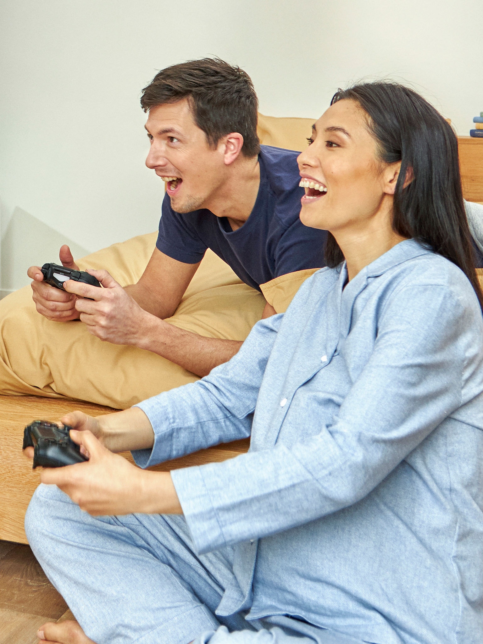 Pregnant couple enjoying playing a videogame in their bedroom