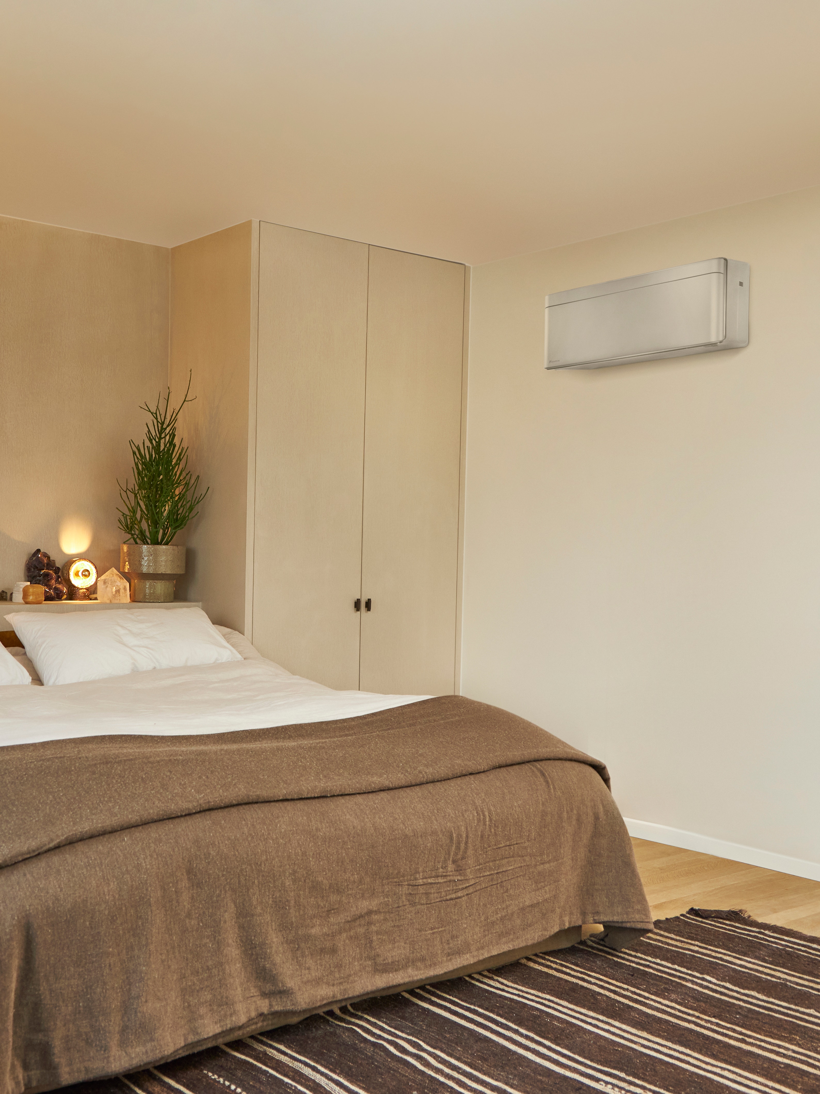 Bedroom with big bed and a wall-mounted climate solution