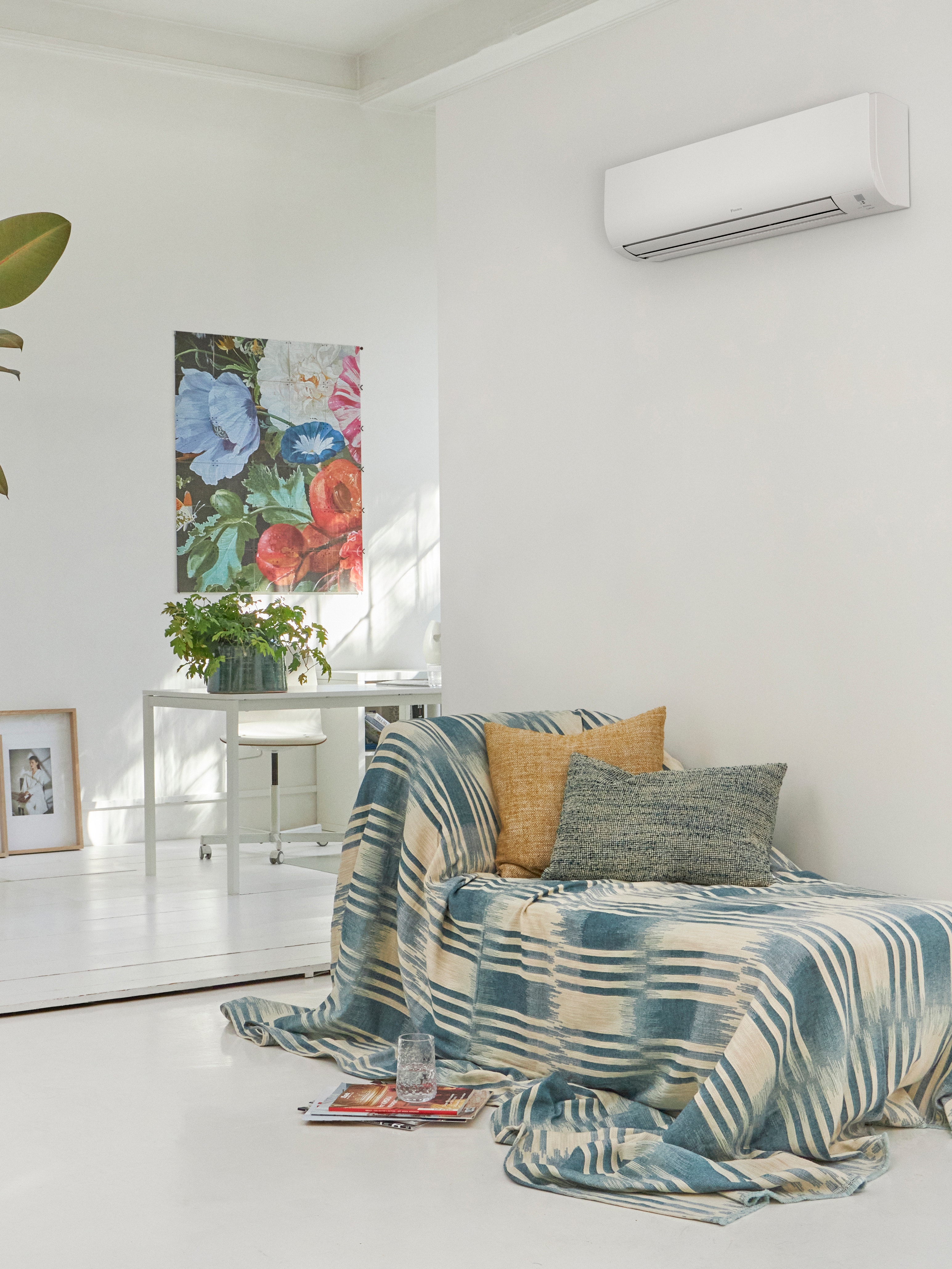 White living room with couch in it and a wall-mounted climate solution above it