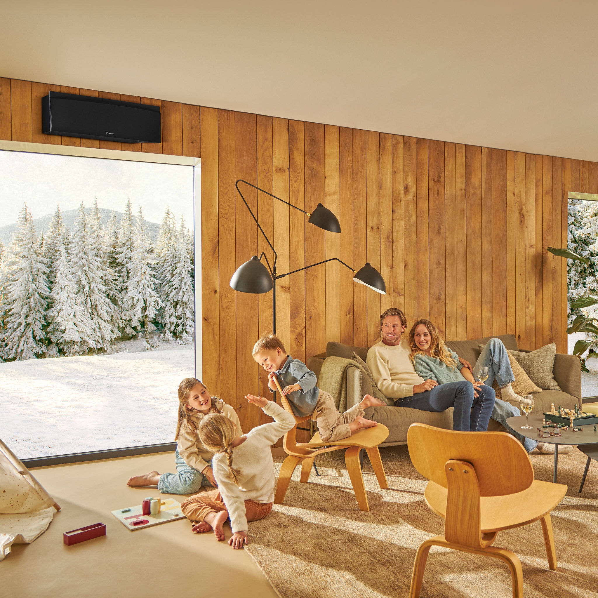 Family enjoying a warm, cozy living room with a winter landscape outside, showcasing the effectiveness of our heating, cooling, and ventilation solutions in creating a comfortable indoor environment year-round
